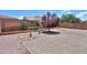 The backyard has gravel landscaping, a small tree, desert landscaping, and a brick-tiled patio at 36255 W Marin Ave, Maricopa, AZ 85138