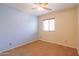 Bedroom featuring neutral walls, carpet flooring, ceiling fan, and natural light from the window at 36255 W Marin Ave, Maricopa, AZ 85138