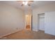 Bedroom with a closet, fan and carpet; features an ensuite entry and neutral walls at 36255 W Marin Ave, Maricopa, AZ 85138