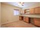 Bedroom featuring carpet flooring, a ceiling fan, and custom built-in cabinets and workspace at 36255 W Marin Ave, Maricopa, AZ 85138