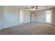 Spacious carpeted bedroom with ceiling fan and access to the outside at 36255 W Marin Ave, Maricopa, AZ 85138