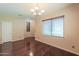 Open dining area with hardwood floors, chandelier lighting, and a large window with blinds at 36255 W Marin Ave, Maricopa, AZ 85138