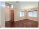 Bright, open floor plan with hardwood floors, a dining area, and a glimpse of the front door at 36255 W Marin Ave, Maricopa, AZ 85138