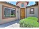 Inviting front exterior with a warm-toned wooden door and lush green landscaping at 36255 W Marin Ave, Maricopa, AZ 85138