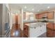Bright kitchen with stainless steel appliances, a center island, wood floors, and an opening to dining room at 36255 W Marin Ave, Maricopa, AZ 85138