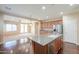 Open-concept kitchen features wood floors, stainless appliances, granite counters, and flows into the living space at 36255 W Marin Ave, Maricopa, AZ 85138