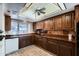 Traditional kitchen with brown cabinetry, tile floors, and modern appliances at 365 Leisure World --, Mesa, AZ 85206