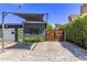 Modern home with a green door, wooden gate, stylish carport, and neatly trimmed shrubbery at 3710 E Altadena Ave, Phoenix, AZ 85028