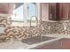 Close-up of kitchen sink, granite countertops, mosaic tile backsplash, and stainless steel faucet at 3710 E Altadena Ave, Phoenix, AZ 85028
