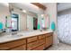 Bathroom with double sink vanity, large mirror, and tiled shower/tub combo at 3723 W Columbine Dr, Phoenix, AZ 85029