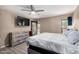 Spacious bedroom with a large window, wooden dresser, and modern ceiling fan at 3723 W Columbine Dr, Phoenix, AZ 85029