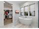Spa-like bathroom featuring a modern freestanding tub, sleek fixtures, and a view of the walk-in closet at 3808 E Fairmount Ave, Phoenix, AZ 85018