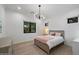 Bright bedroom with wood floors, large windows, and a modern chandelier at 3808 E Fairmount Ave, Phoenix, AZ 85018
