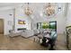 Open-concept living room with vaulted ceilings, modern chandeliers, fireplace, and sliding doors to the outdoor patio at 3808 E Fairmount Ave, Phoenix, AZ 85018