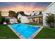 Beautiful backyard pool with lounge chairs and manicured lawn at dusk with access to the home's interior at 3808 E Fairmount Ave, Phoenix, AZ 85018