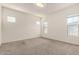 Bright bedroom featuring neutral carpet, a modern light fixture, and multiple windows for ample natural light at 3894 E Dogwood Pl, Chandler, AZ 85286
