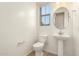 Clean powder room featuring a pedestal sink, toilet, and window at 3894 E Dogwood Pl, Chandler, AZ 85286