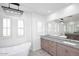 Modern bathroom with a soaking tub, large vanity, and stylish pendant lighting at 3931 E Crest Ln, Phoenix, AZ 85050