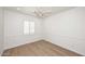 Simple bedroom with hardwood floors, white walls, a ceiling fan and shuttered window at 3931 E Crest Ln, Phoenix, AZ 85050