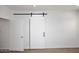 Spacious bedroom featuring light wood floors and a modern barn door for easy access at 3931 E Crest Ln, Phoenix, AZ 85050