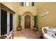 Inviting front entrance with a quaint welcome sign, a beautiful arched door and tiled patio at 3931 E Crest Ln, Phoenix, AZ 85050