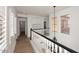Upstairs hallway with wood floors, white wainscotting, and modern lighting at 3931 E Crest Ln, Phoenix, AZ 85050