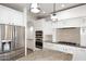Bright kitchen with white cabinetry, granite countertops, stainless steel appliances, and decorative pendant lighting at 3931 E Crest Ln, Phoenix, AZ 85050