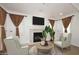 Living room with a fireplace, television, matching chairs, plants and window coverings at 3931 E Crest Ln, Phoenix, AZ 85050