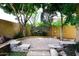 Cozy brick patio area shaded by mature trees and accented by a stacked stone wall with natural stone seating at 3931 E Crest Ln, Phoenix, AZ 85050