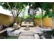 Tranquil outdoor patio area featuring comfortable seating and a stone fire pit, surrounded by lush landscaping at 3931 E Crest Ln, Phoenix, AZ 85050