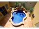 An aerial view of a unique blue-tiled pool and spa surrounded by a terracotta patio, creating a luxurious outdoor oasis at 3931 E Crest Ln, Phoenix, AZ 85050