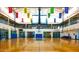 Indoor basketball court with banners, bleachers, and second-story track for recreational games and community events at 40807 N Barnum Way, Anthem, AZ 85086