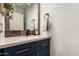 Stylish powder room with a dark blue vanity, marble mirror frame and modern fixtures at 40807 N Barnum Way, Anthem, AZ 85086