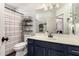 Charming bathroom features navy vanity with gold hardware, updated fixtures, decorative shelving, and a shower at 40807 N Barnum Way, Anthem, AZ 85086