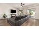 Relaxing living room with a leather sectional couch, ceiling fan, patio access and natural light at 40807 N Barnum Way, Anthem, AZ 85086