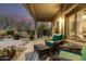 Covered patio with comfortable wicker furniture to enjoy the beautiful landscaped backyard and twilight skies at 40807 N Barnum Way, Anthem, AZ 85086