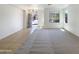 Spacious living room features neutral carpet, an open doorway, and large windows at 41344 W Laramie Rd, Maricopa, AZ 85138