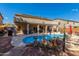 Backyard pool with rock waterfall, patio area, desert landscaping, and clear blue sky at 4321 E Morenci Rd, San Tan Valley, AZ 85143