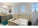 Bright bathroom featuring a jacuzzi tub, dual windows, vanity, and elegant fixtures at 4321 E Morenci Rd, San Tan Valley, AZ 85143