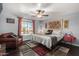 Well-lit bedroom featuring a large window, eclectic art, accent chair, and dark wood floors at 4321 E Morenci Rd, San Tan Valley, AZ 85143