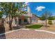A sprawling backyard features a lush artificial lawn, pool, mature trees and a charming patio at 453 E Baylor Ln, Gilbert, AZ 85296