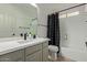 A beautifully updated bathroom with a large mirror, gray cabinets, and a shower with a stylish shower curtain at 453 E Baylor Ln, Gilbert, AZ 85296