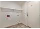Bright laundry room features convenient shelving, washer/dryer hookups, and attractive flooring for efficient home management at 453 E Baylor Ln, Gilbert, AZ 85296