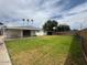 Large, fenced backyard with green lawn, mature trees, and covered patio at 4602 N 50Th Ave, Phoenix, AZ 85031