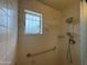 Bathroom featuring a window for natural light and a shower with safety bar at 4602 N 50Th Ave, Phoenix, AZ 85031