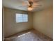 Bedroom with a window overlooking the outdoors, ceiling fan, and carpeted floors at 4602 N 50Th Ave, Phoenix, AZ 85031