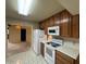 Functional kitchen with white appliances, wooden cabinetry, and tiled flooring at 4602 N 50Th Ave, Phoenix, AZ 85031