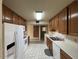 View of the kitchen featuring white appliances, white countertops and wooden cabinetry at 4602 N 50Th Ave, Phoenix, AZ 85031