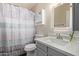 Bright bathroom featuring a shower with a striped curtain, modern vanity, framed mirror, and new lighting at 520 N Stapley Dr # 256, Mesa, AZ 85203