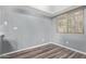 A light blue empty room with a window and wood-look floors ready to be furnished at 520 N Stapley Dr # 256, Mesa, AZ 85203